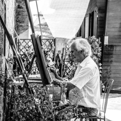 old man painting on canvass