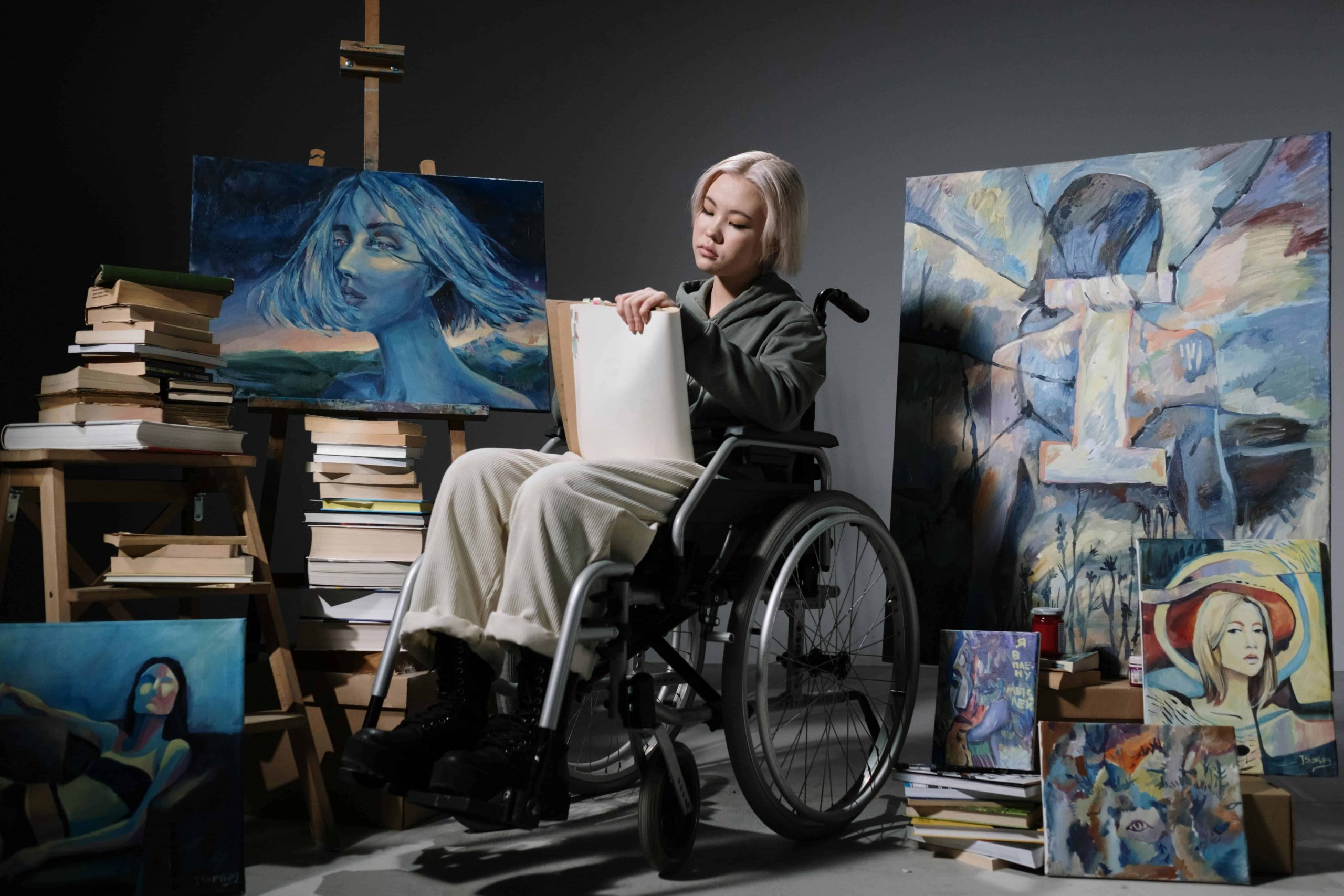girl on wheel chair doing painting